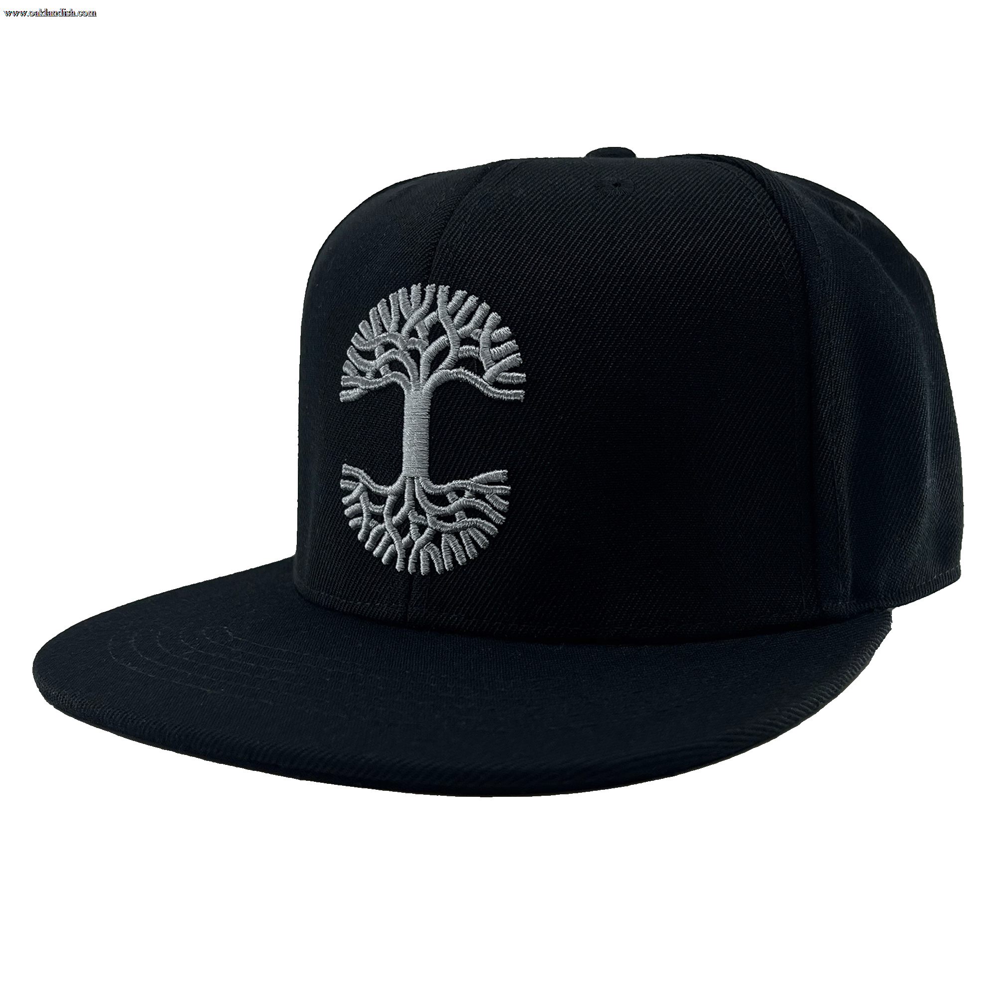 The Town Aft Snapback by Oaklandish is a black, flat-brimmed hat featuring a grey embroidered Oaklandish tree logo on the front panel. The detailed tree logo showcases an intricate root system and branches, forming a symmetrical circular pattern that spans the center of the adjustable snapback. This hat has a structured crown and is made from textured fabric.