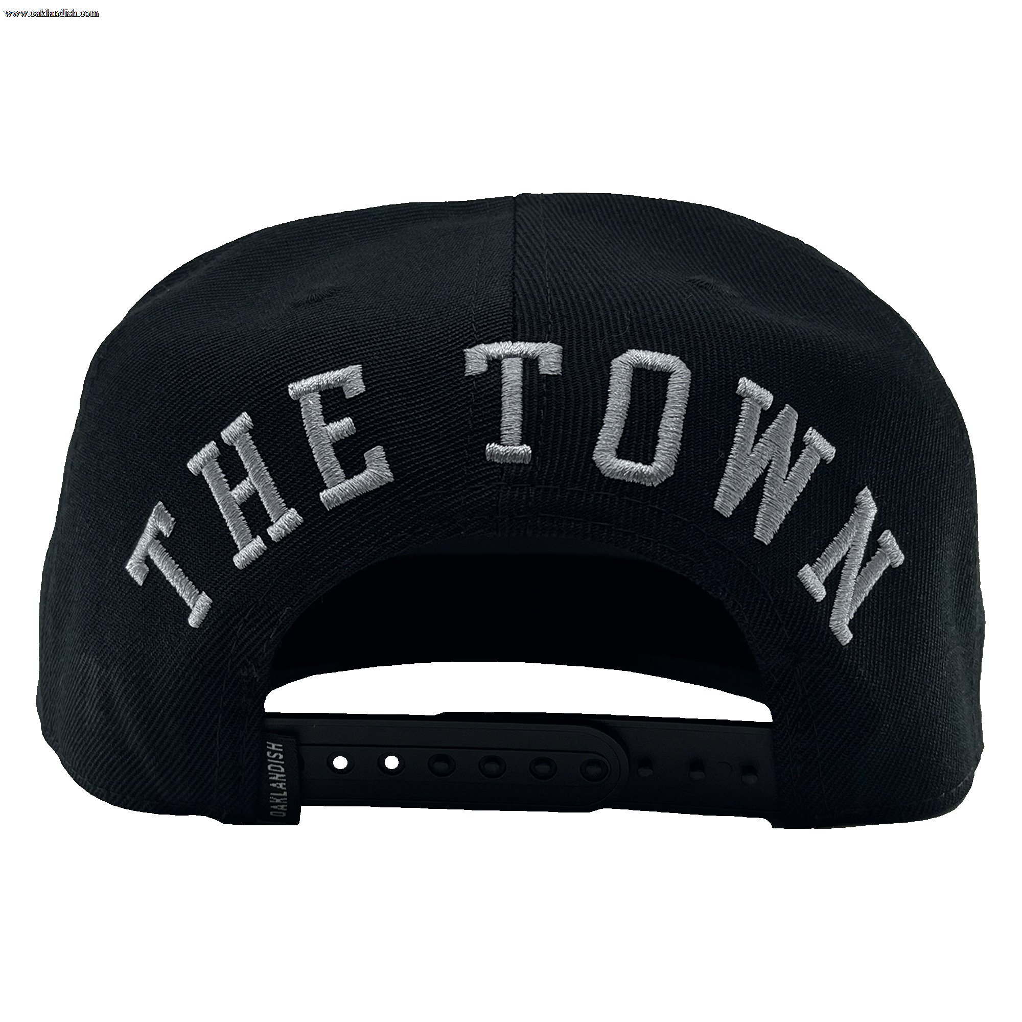The rear view of "The Town Aft Snapback" by Oaklandish features "THE TOWN" prominently embroidered in large white letters. The hat's adjustable snapback closure, a small label tag on the side, and an embroidered Oaklandish tree logo are also visible.